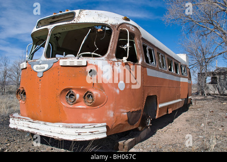 Un vecchio autobus abbandonato siede silenziosamente in un lotto vacante al di fuori della città di Carrizozo, Nuovo Messico. Foto Stock