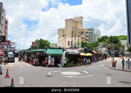 Aria aperta negozi, cartelli pubblicitari, acquirenti e consegna van in corrispondenza di un nodo stradale presso il Mercato Stanley, Hong Kong, Cina Foto Stock