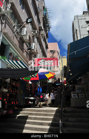 Le donne cinesi a piedi giù il vicolo della scaletta passi passato aria aperta di bagagli e artwork negozi, il Mercato Stanley, Stanley, Hong Kong, Cina Foto Stock