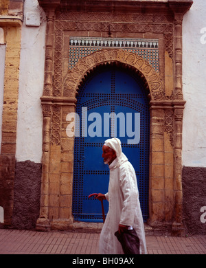 Un uomo anziano oltrepassando una porta blu in una strada nella medina essaouira marocco Foto Stock