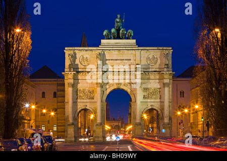 Il Siegestor (Vittoria Gate) con il traffico che fluisce intorno al tramonto nel quartiere di Schwabing nella città di München (Monaco di Baviera), B Foto Stock