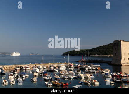 Porto di Dubrovnik con piccole barche da pesca e grande nave da crociera ormeggiata nella baia della Croazia Foto Stock