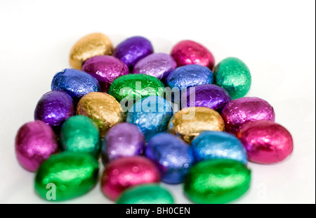Una selezione di coloratissimi mini uova di pasqua di cioccolato su uno sfondo bianco Foto Stock