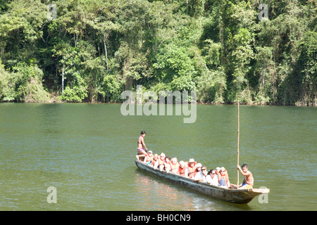 Turisti europei in piroga gestiti da giovani uomini, Embera villaggio indiano. Chagres National Park. Panama. America centrale Foto Stock