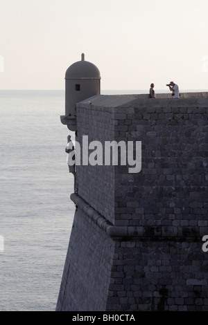 Giovane tenendo fotografia mura della città di Dubrovnik Città Vecchia Croazia crepuscolo Foto Stock