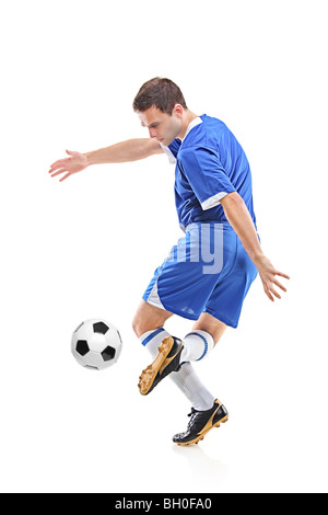 Giovane giocatore di calcio con una palla contro uno sfondo bianco Foto Stock