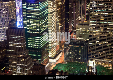 Vista dall' Empire State Building close up di grattacieli di Avenue of the Americas, Bryant Park e Times Square di notte tempo. Foto Stock