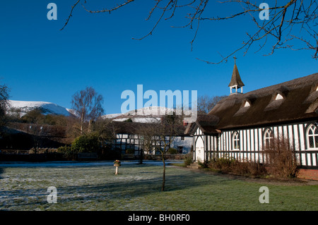 Tutti chiesetta, Little Stretton, Shropshire, in inverno con il Longmynd in background Foto Stock