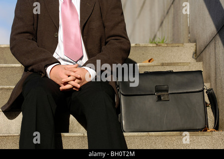 Business man si siede su alcune fasi Foto Stock