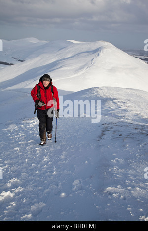 Hillwalker in una giacca rossa sulla coperta di neve Pentland Hills nei pressi di Edimburgo, Scozia Foto Stock