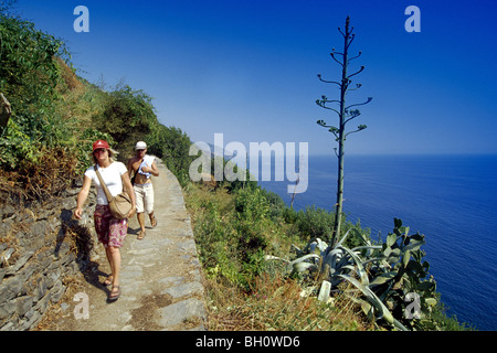 Gli escursionisti su un sentiero lungo la costa rocciosa sotto il cielo blu, Cinque Terre Liguria, Riviera Ligure, Italia, Europa Foto Stock