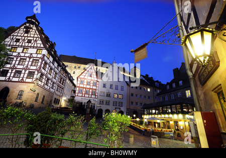 Semi-case di legno con castello in background in serata, Norimberga, Media Franconia, Baviera, Germania Foto Stock