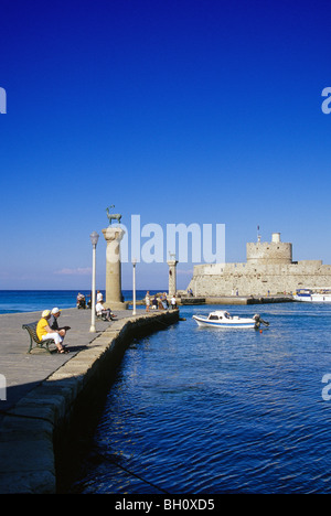 Coppia matura seduta su una panchina all'entrata del porto di Mandraki Harbour, Città di Rodi Isola di Rodi, Grecia, Europa Foto Stock