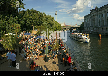 La gente di relax presso la banca del fiume Spree nella luce del sole, l'Isola dei Musei di Berlino, Germania, Europa Foto Stock