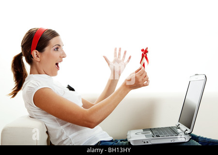 Giovane e bella donna che mantiene la sua migliore presente, una carta di credito. Il consumismo concept Foto Stock