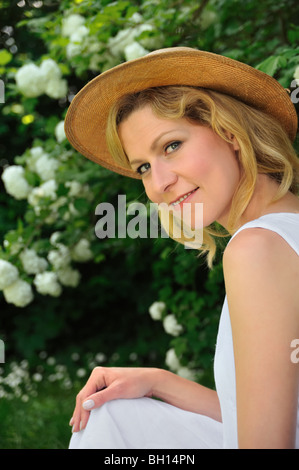 Giovane donna di riposo in giardino Foto Stock