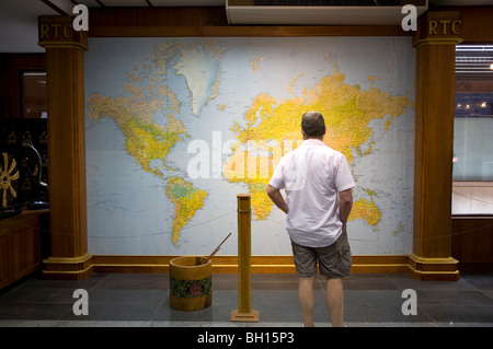 Uomo in piedi nella parte anteriore della mappa del mondo Foto Stock