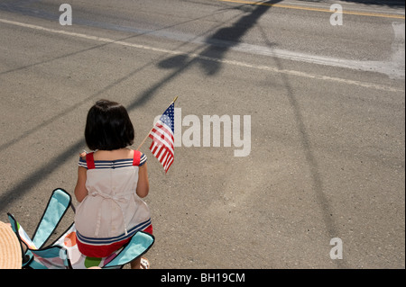 Ragazza con bandiera americana durante il 4 di luglio parade. Foto Stock