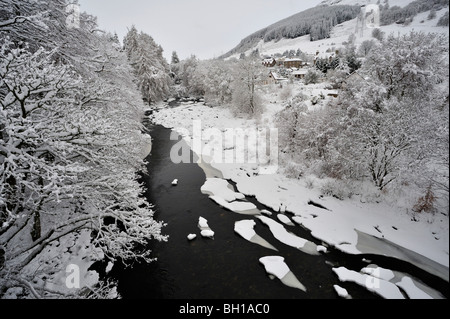 Snowy viale alberato di argini di fiumi e parzialmente frozen river visto da sopra Foto Stock