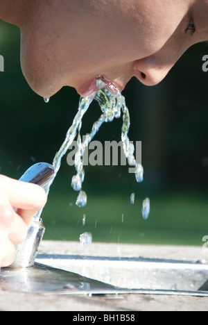 Donna asiatica bevande acqua dalla fontana di Assiniboine Park, Winnipeg, Manitoba, Canada Foto Stock