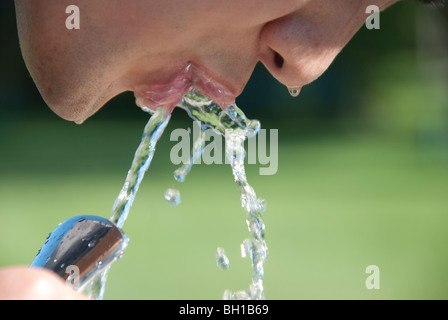 Uomo asiatico bevande acqua dalla fontana di Assiniboine Park, Winnipeg, Manitoba, Canada Foto Stock