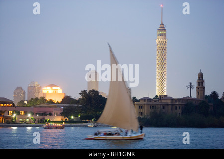 Feluka sul fiume Nilo al tramonto, Torre de Il Cairo e opera in background, il Cairo, Egitto, Africa Foto Stock