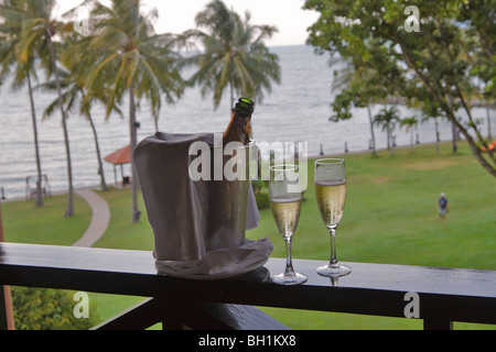 Una benna con champagne e due bicchieri su un balcone in un resort tropicale Foto Stock