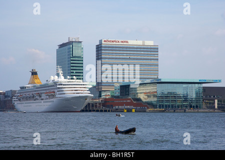 La nave di crociera sul fiume Het IJ vicino a edifici alti, Amsterdam, Paesi Bassi, Europa Foto Stock