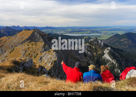 Gli escursionisti godendo di vista sulle Alpi Ammergau, lago di Forggensee in background, Klammspitze, Alpi Ammergau, Pfaffenwinkel, Baviera, germe Foto Stock