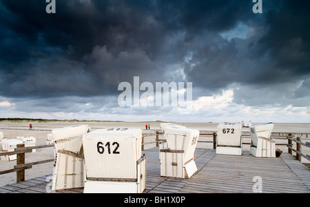 Sedie a sdraio sulla spiaggia sotto le nuvole scure, San Pietro Ording, penisola di Eiderstedt, Schleswig Holstein, Germania, Europa Foto Stock