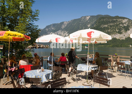 Gli ospiti seduti sulla terrazza di un caffè presso il lago Hallstatt, Hallstatt, Salzkammergut, Austria superiore, Austria Foto Stock