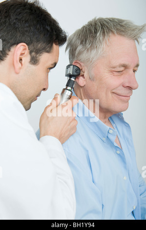 La metà degli adulti controlli medico audizione del paziente senior Foto Stock