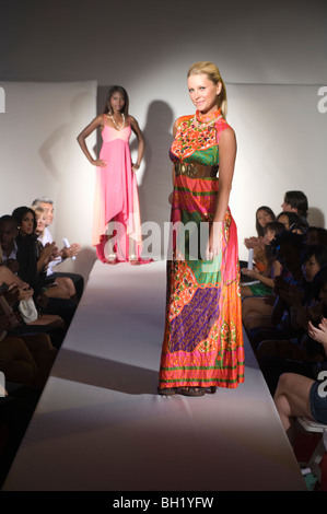 Donna in abiti multicolore sulla passerella per sfilate di moda Foto Stock
