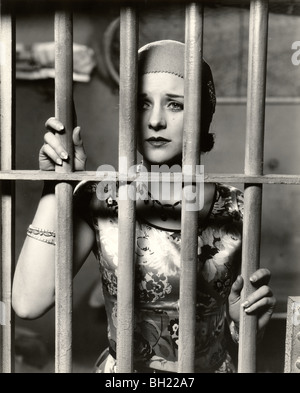 Bella donna dietro le sbarre in carcere Foto Stock