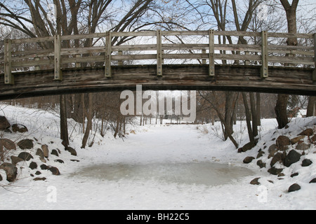 Un piede ponte congelati Minnehaha Creek a Minneapolis, Minnesota. Foto Stock