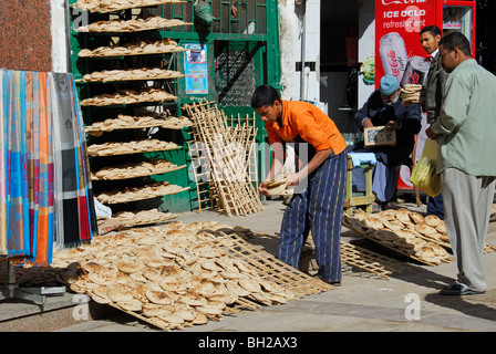 ASWAN, Egitto. Un panificio vendere flatbread ("aish shamsi) nel mercato di Aswan. 2009. Foto Stock