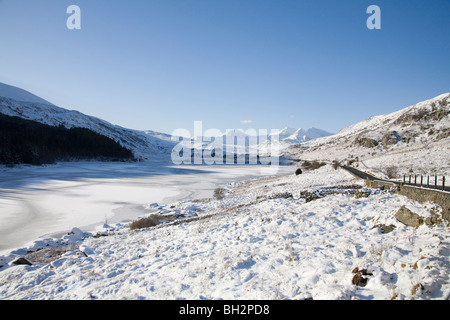 Capel Curig Conwy North Wales UK Gennaio guardando attraverso congelati Mymbyr Llynnau alla coperta di neve Snowdon Horseshoe Parco Nazionale di Snowdonia Foto Stock