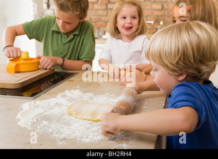 Quattro bambini i biscotti di cottura Foto Stock
