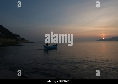 Pescatore solitario all'alba in Runswick Bay Foto Stock