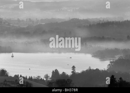 Guardando verso una nebbiosa Windermere, da Kirkstone pass al di sopra di Ambleside, come una barca sul lago. Foto Stock