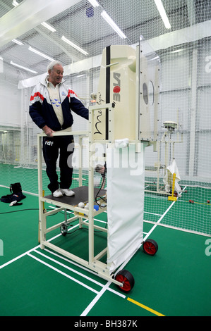 Sussex cricket coach usando Merlyn da BOLA spin bowling macchina nelle reti di pratica presso la scuola interna Foto Stock