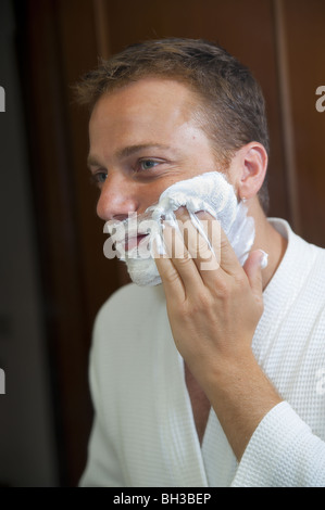 Uomo di mettere la crema di rasatura sulla faccia Foto Stock