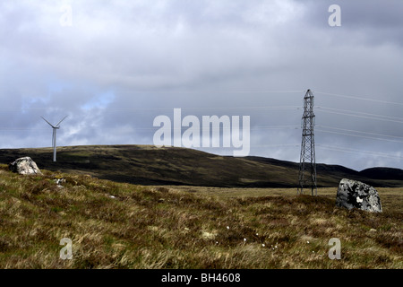 Turbina eolica e traliccio di elettricità sulle colline di Strath Nairn. Foto Stock