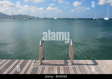 Passi su un pontile in legno che conduce in basso verso il mare Foto Stock