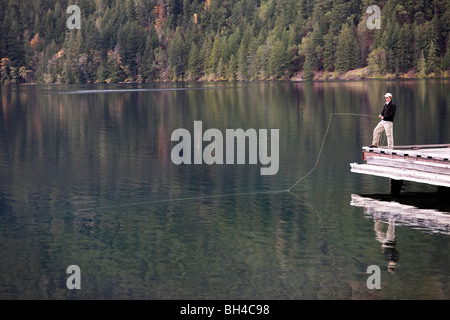 Un uomo volare pesci Lago Crescent a Washington il parco nazionale di Olympic. Foto Stock