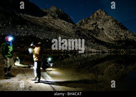 Un gruppo di partecipanti clean up dopo cena sulle rive di un lago in Yosemite Valley, California. Foto Stock