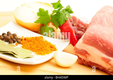 Fette di carne cruda con erbe oltre il bordo. Foto Stock