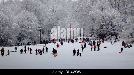 Persone a giocare nella neve invernale scena in Priory Park Reigate, Surrey, Inghilterra Inverno 2010 Foto Stock