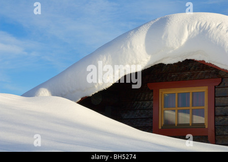 Holiday chalet tetto e finestra dettaglio mostrante derive di neve sul tetto. Foto Stock