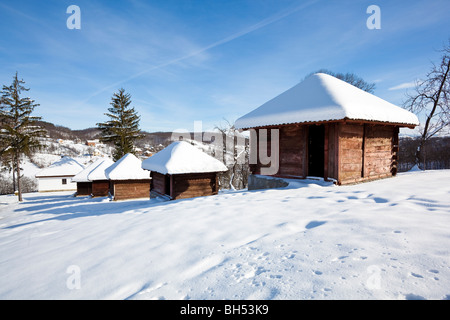 Piccolo villaggio idilliaco Lelic, tradizionale economico serbo edificio "vajat' architettura case in Occidente la Serbia neve invernale Foto Stock